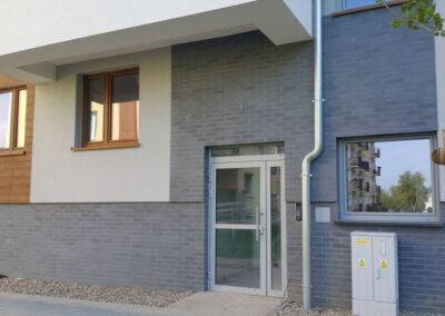 Gorzów Wlkp osiedle mieszkaniowe stolarka aluminiowa – drzwi klatek schodowych sterowane domofonem, sklepowe witryny aluminiowe w pawilonie Żabka